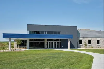 A modern single storey school building with a lawn in front